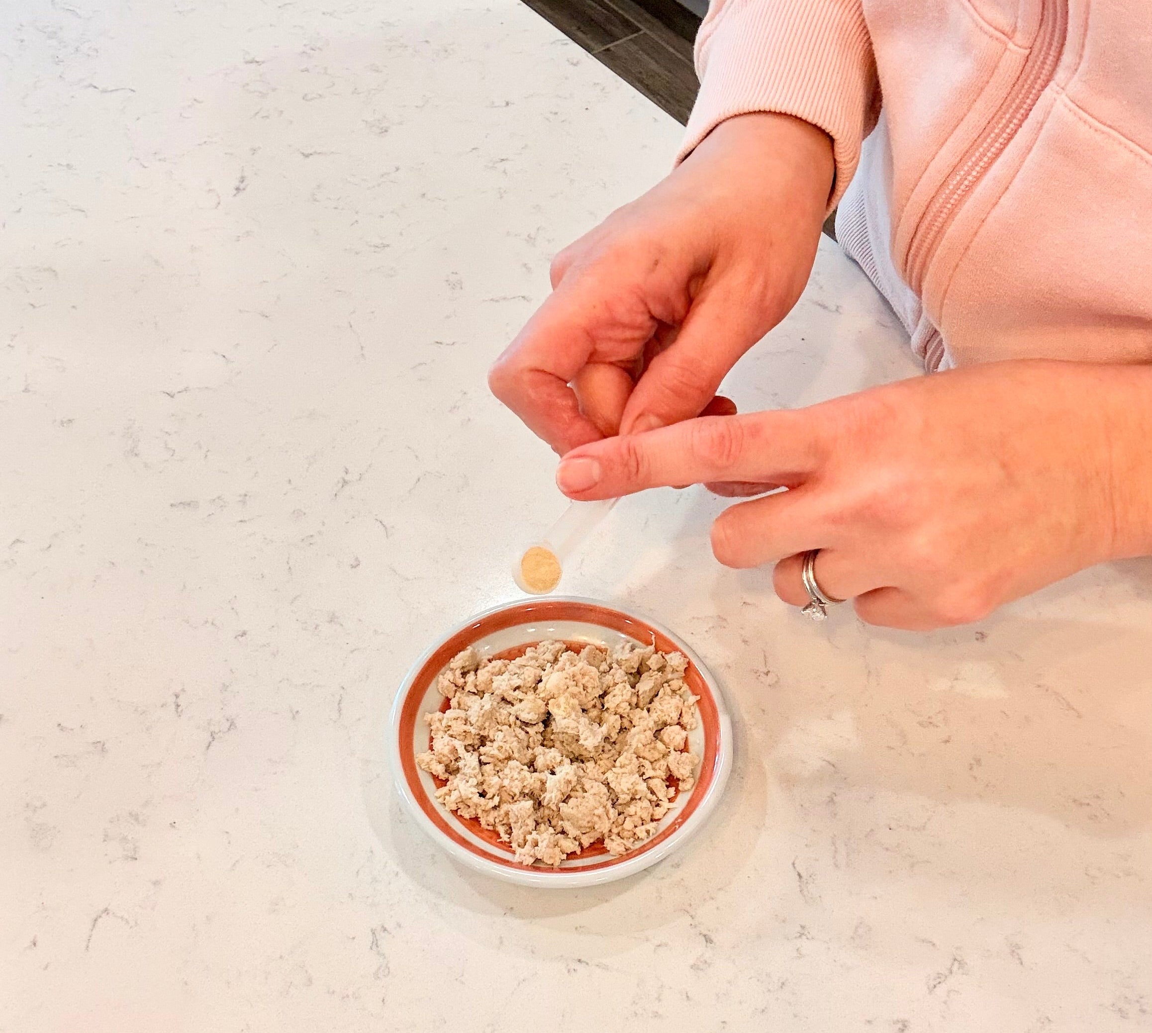 Personal sprinkling Microbiome Booster Supplement onto cat food