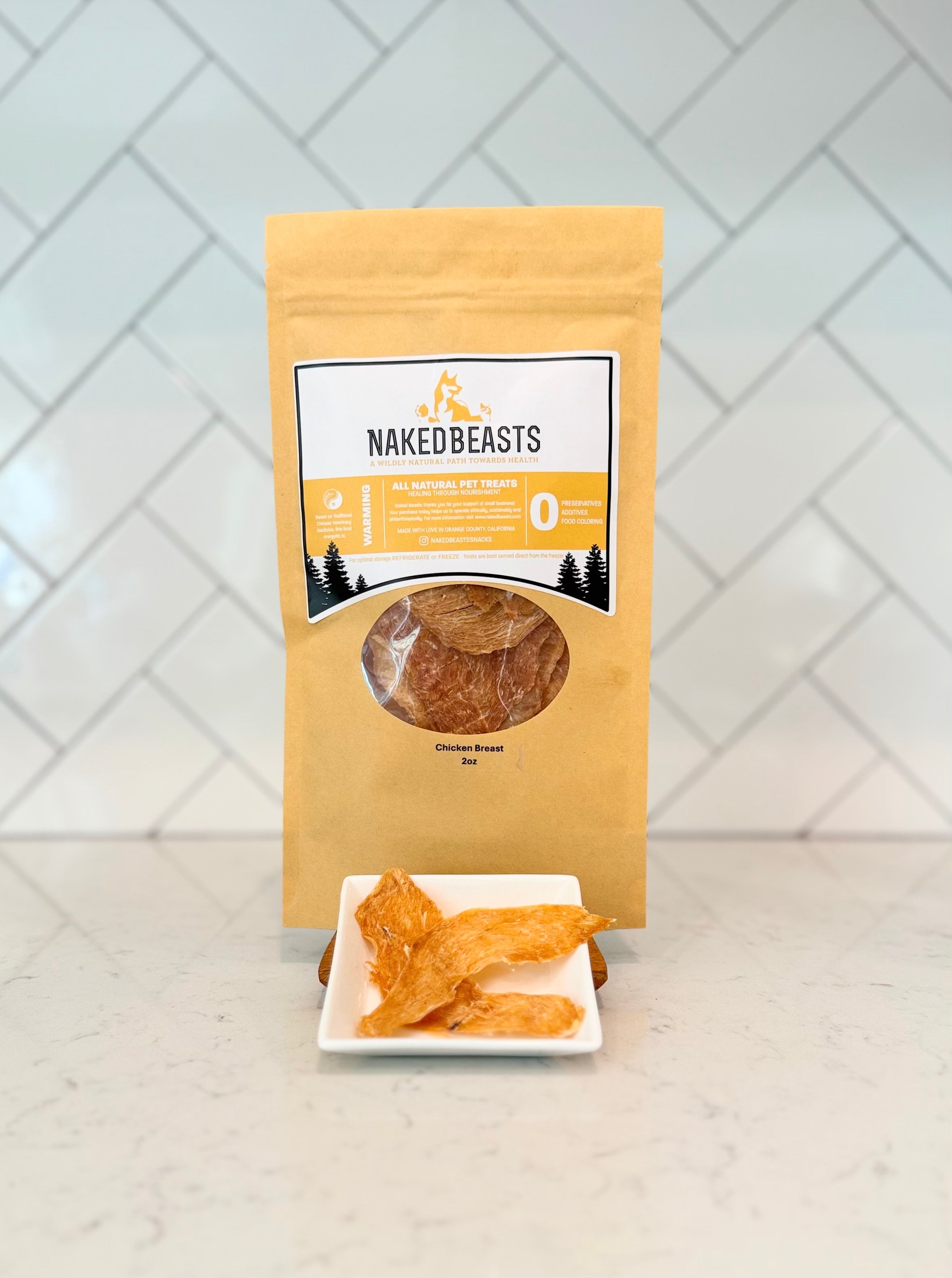 NakedBeasts packaging with dehydrated chicken breast on a white plate against a white tiled wall