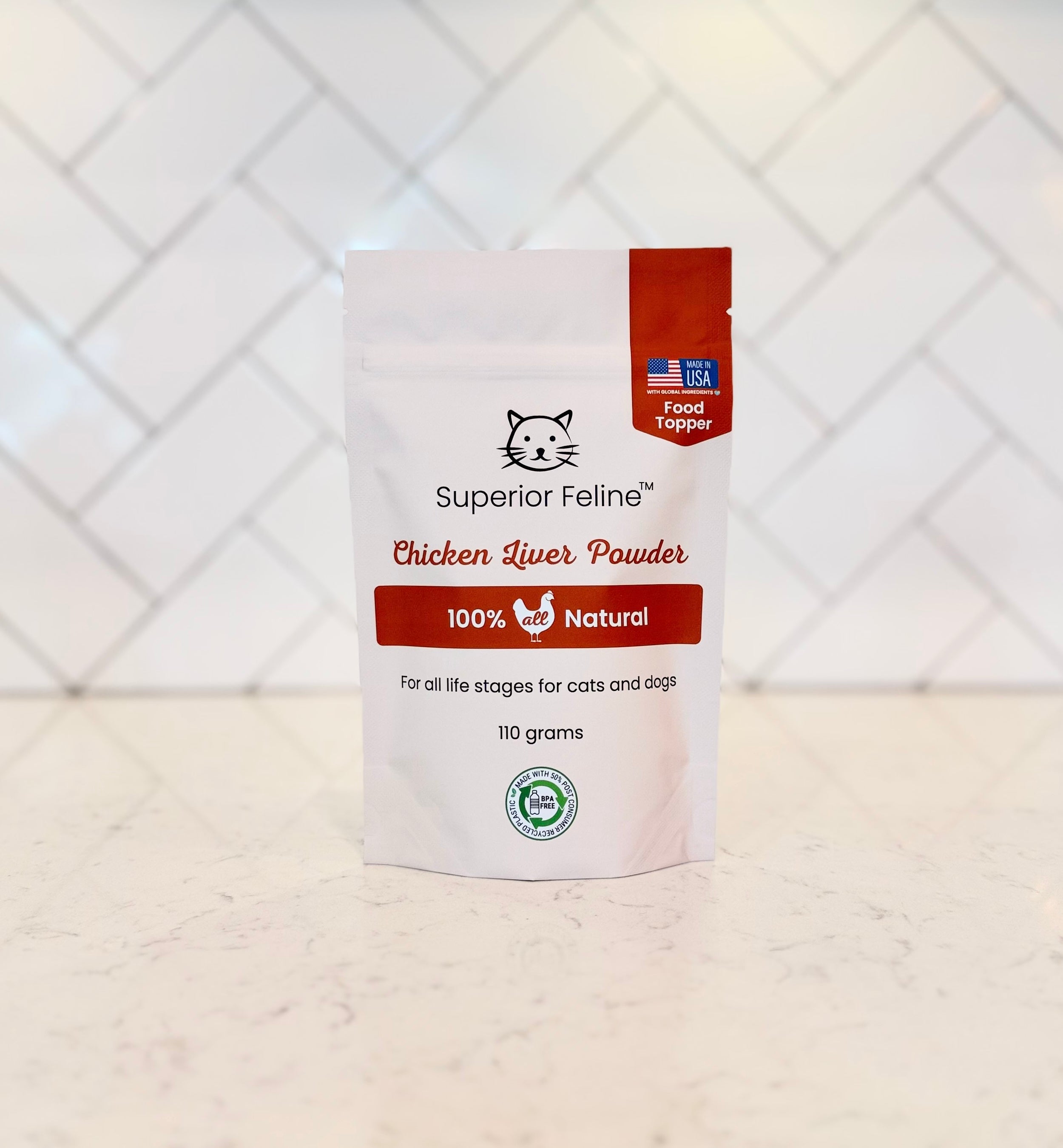 Package of Superior Feline Chicken Liver Powder on a white surface with a white geometric patterned wall in the background.