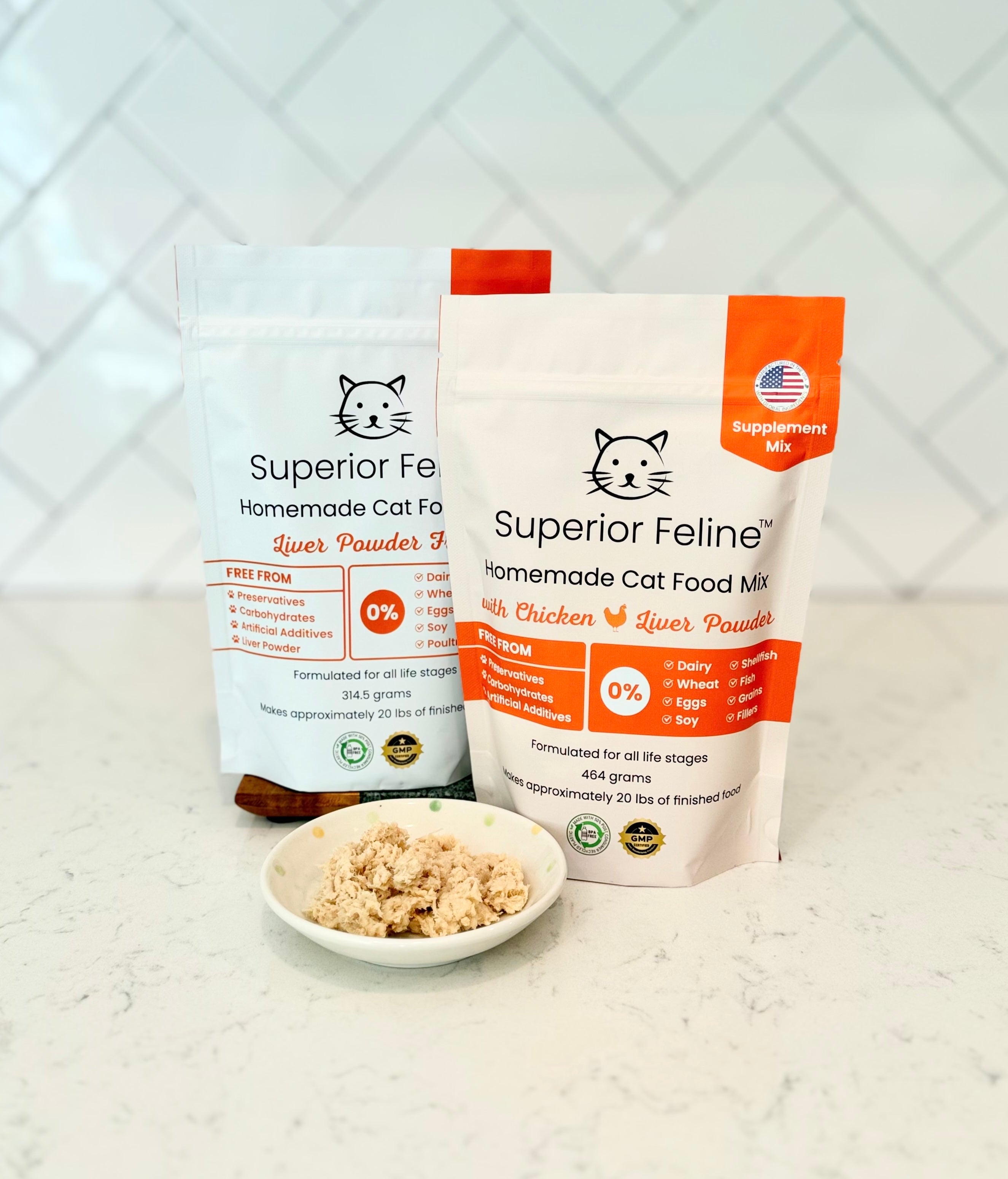 Two packages of Superior Feline Homemade Cat Food Supplement Mix on a white surface with a tiled backsplash.