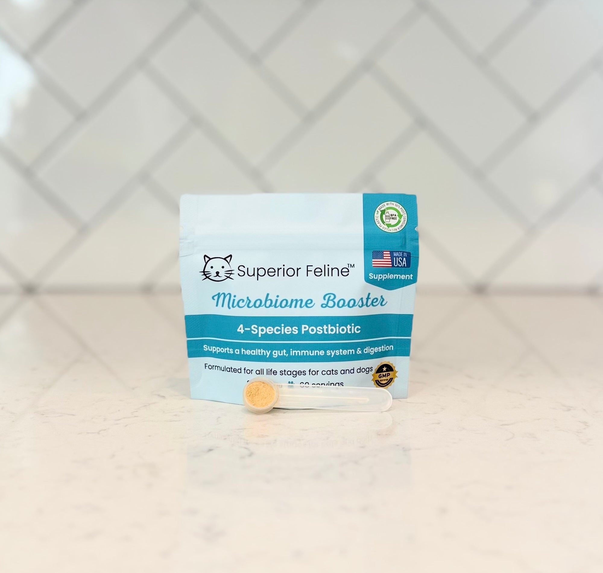 Superior Feline Microbiome Booster packaging with a scoop in front of it on a kitchen countertop with a tiled backsplash
