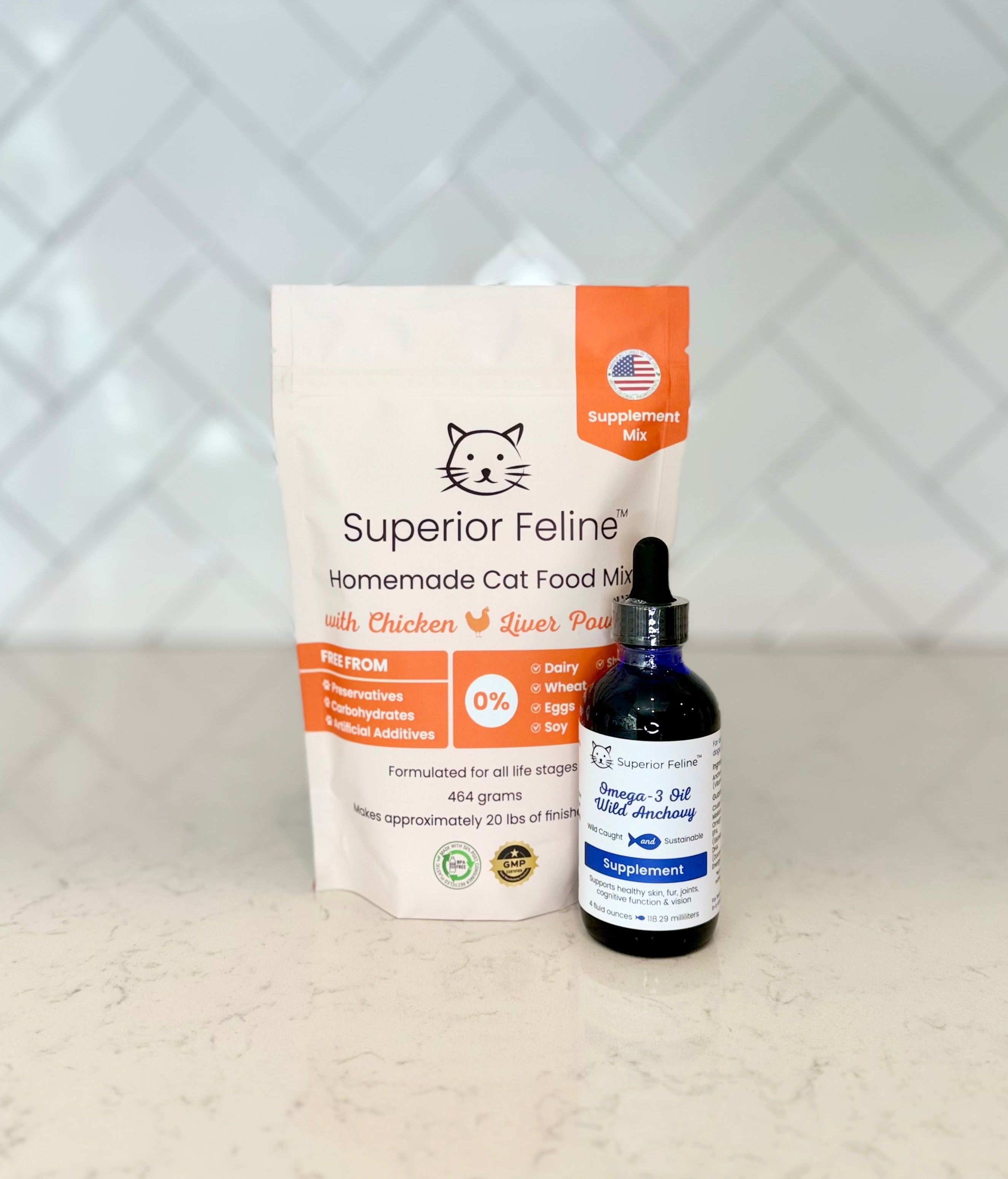 Superior Feline Original Formula Homemade Cat Food Supplement Mix package and bottle of Wild Anchovy Oil on a light countertop surface with a tiled backsplash