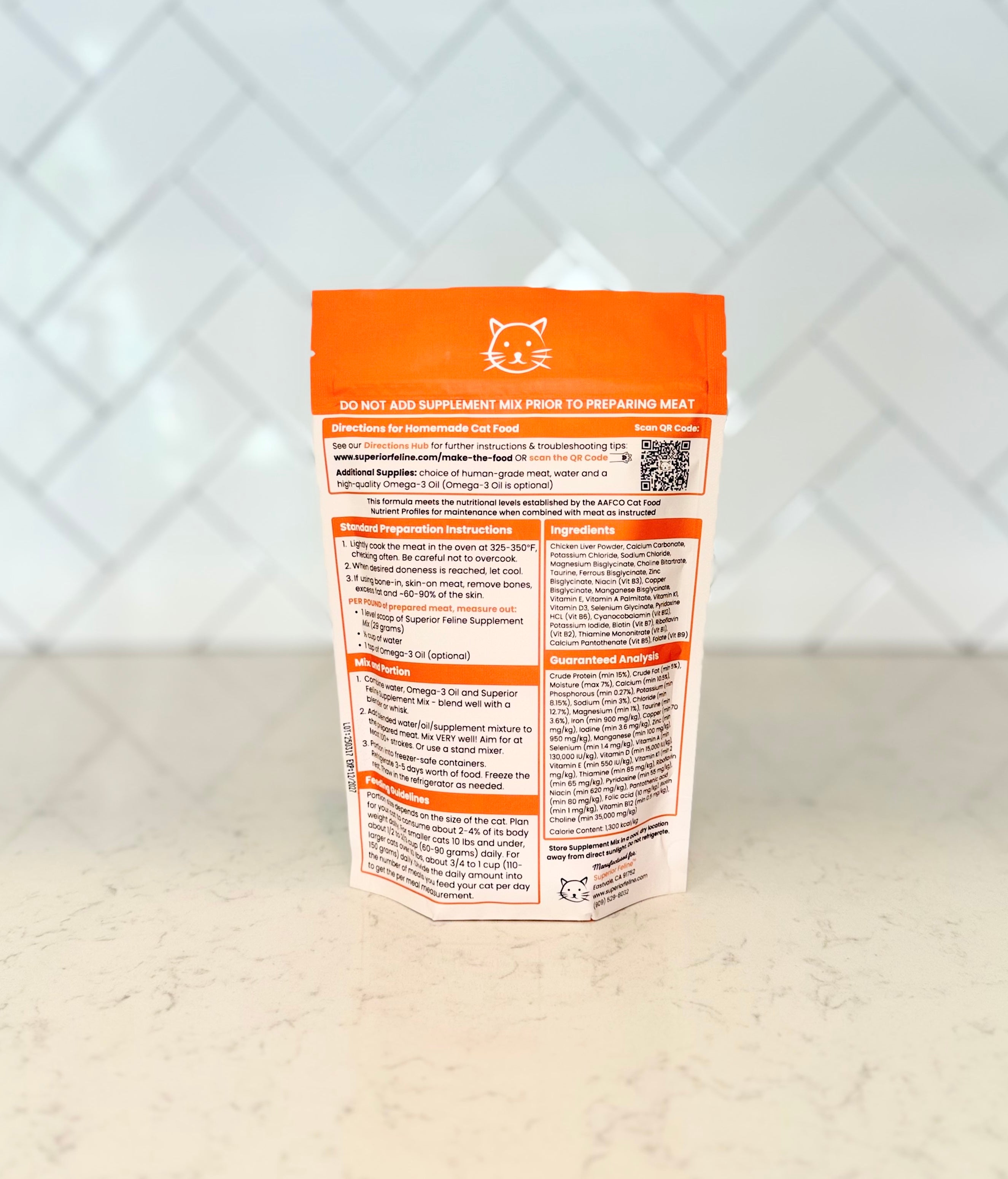 Back view of Superior Feline Original Formula Homemade Cat Food Supplement Mix package with nutritional information on a light countertop surface and tiled backsplash