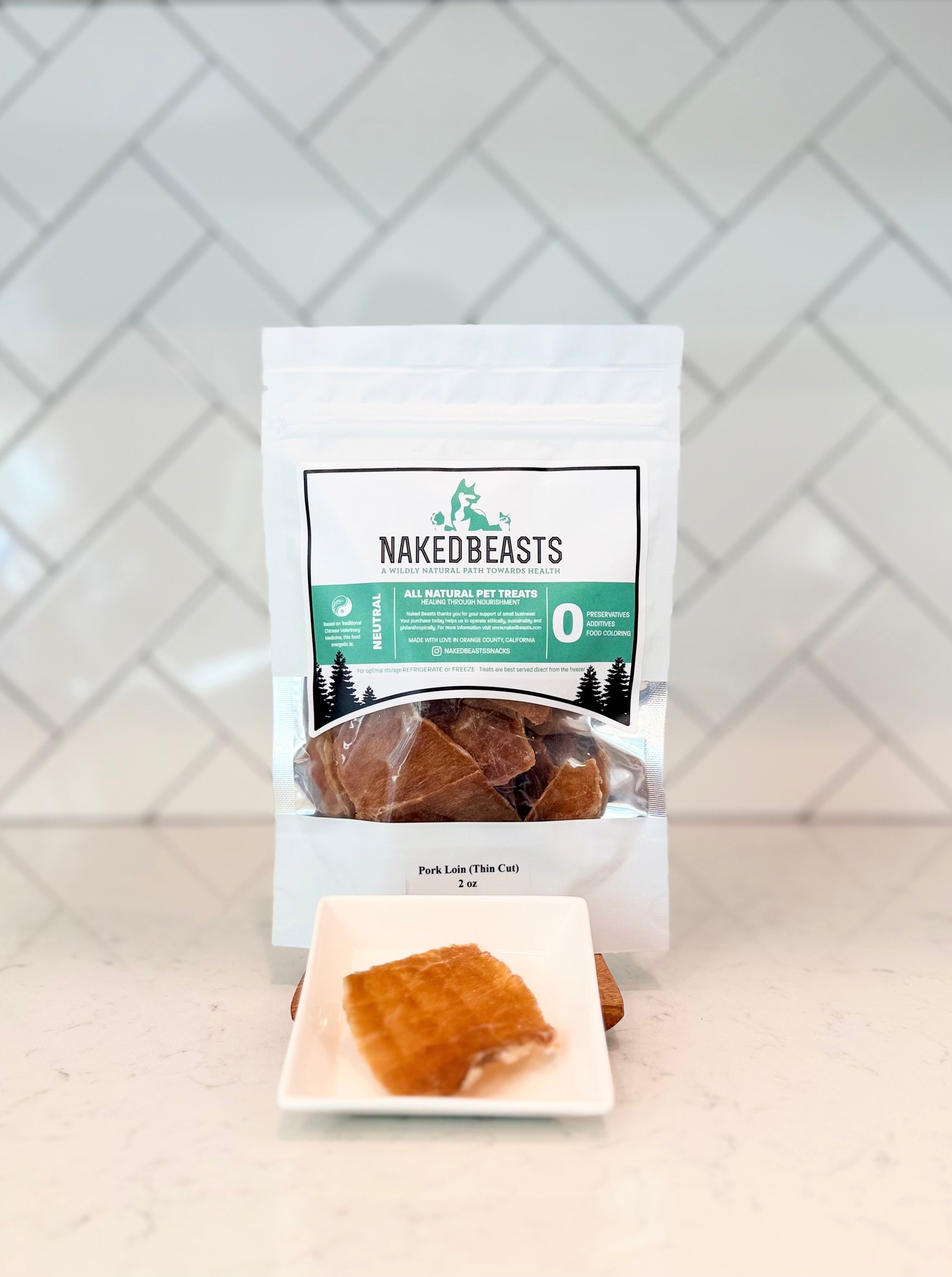 Naked Beasts Pork Loin Snack package on a white surface with a geometric patterned wall in the background