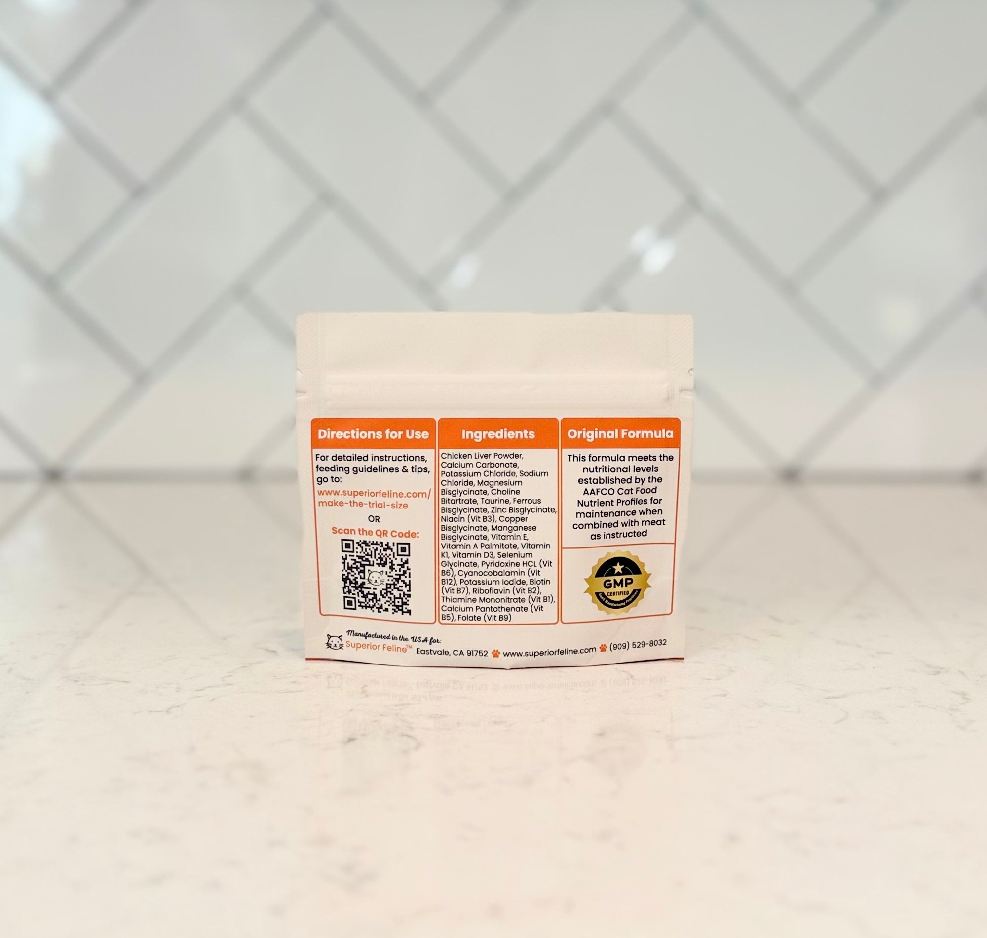 Back view Superior Feline Original Formula Trial Size Homemade Cat Food Supplement Mix package with info about directions and ingredients on a light countertop with tiled backsplash