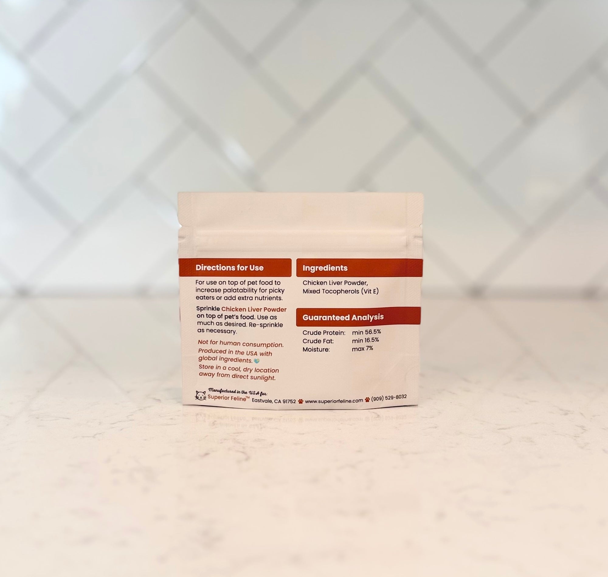 Back view of Trial Size Chicken Liver Powder package with text about directions for use and ingredients, sitting on a kitchen countertop with a tiled backsplash