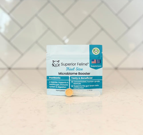 Superior Feline Microbiome Booster with scoop in front on a tiled counter