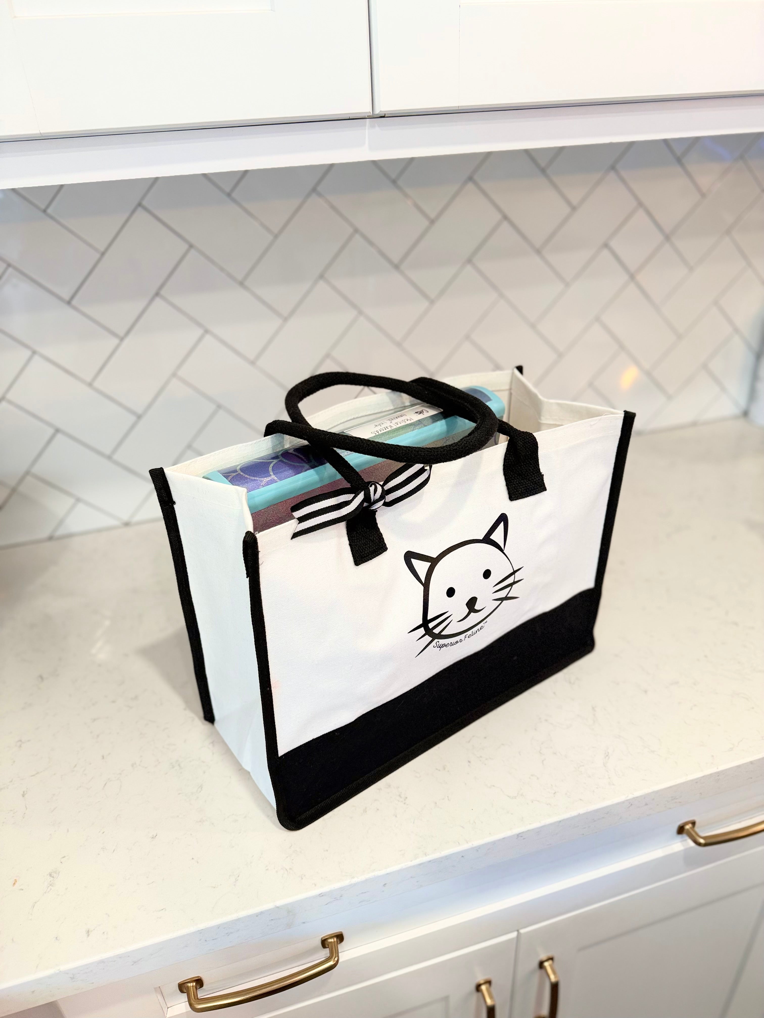 White tote bag with black cat design on a kitchen counter