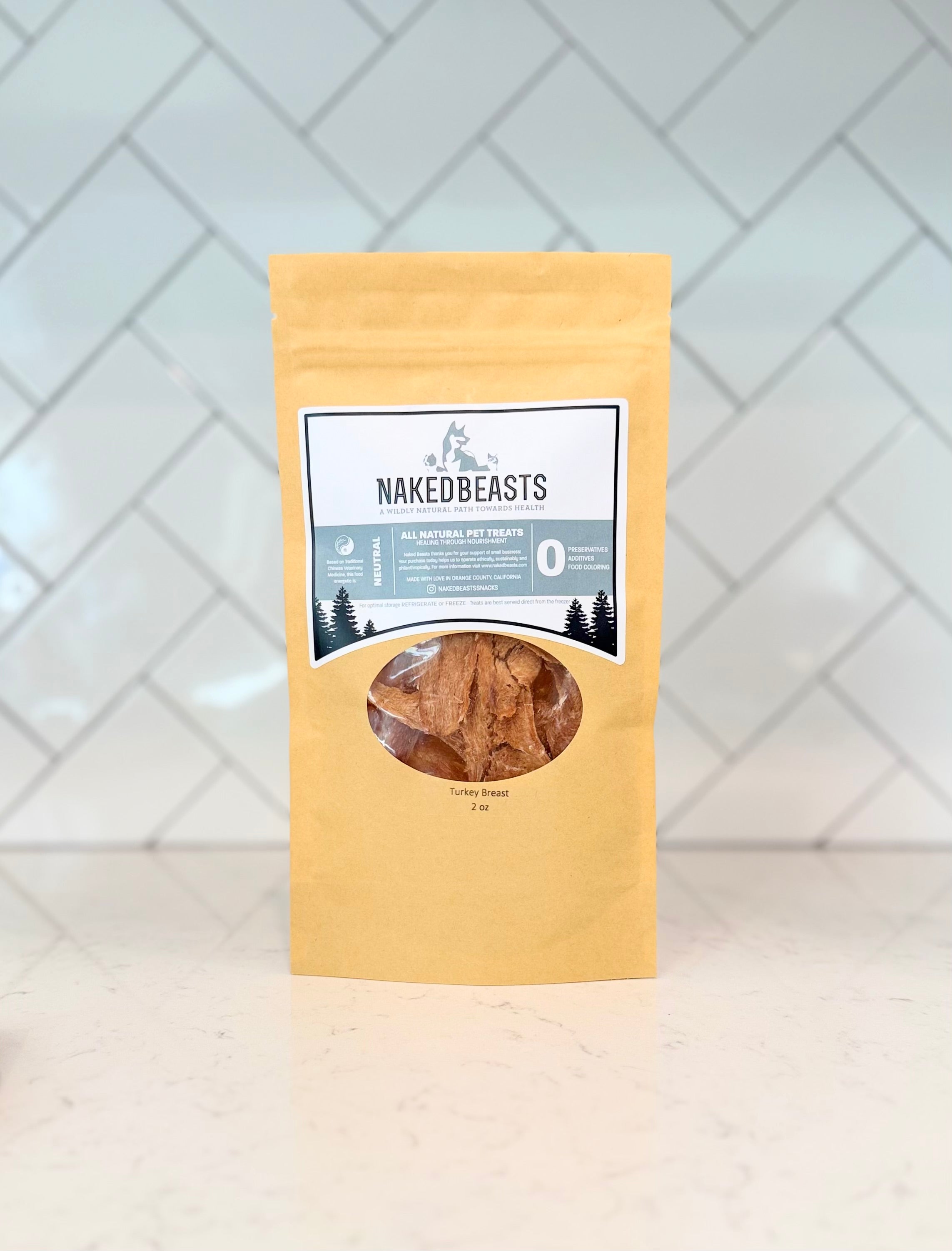 Bag of Naked Beasts Turkey Breast pet snacks on a white surface with a light gray tiled wall background