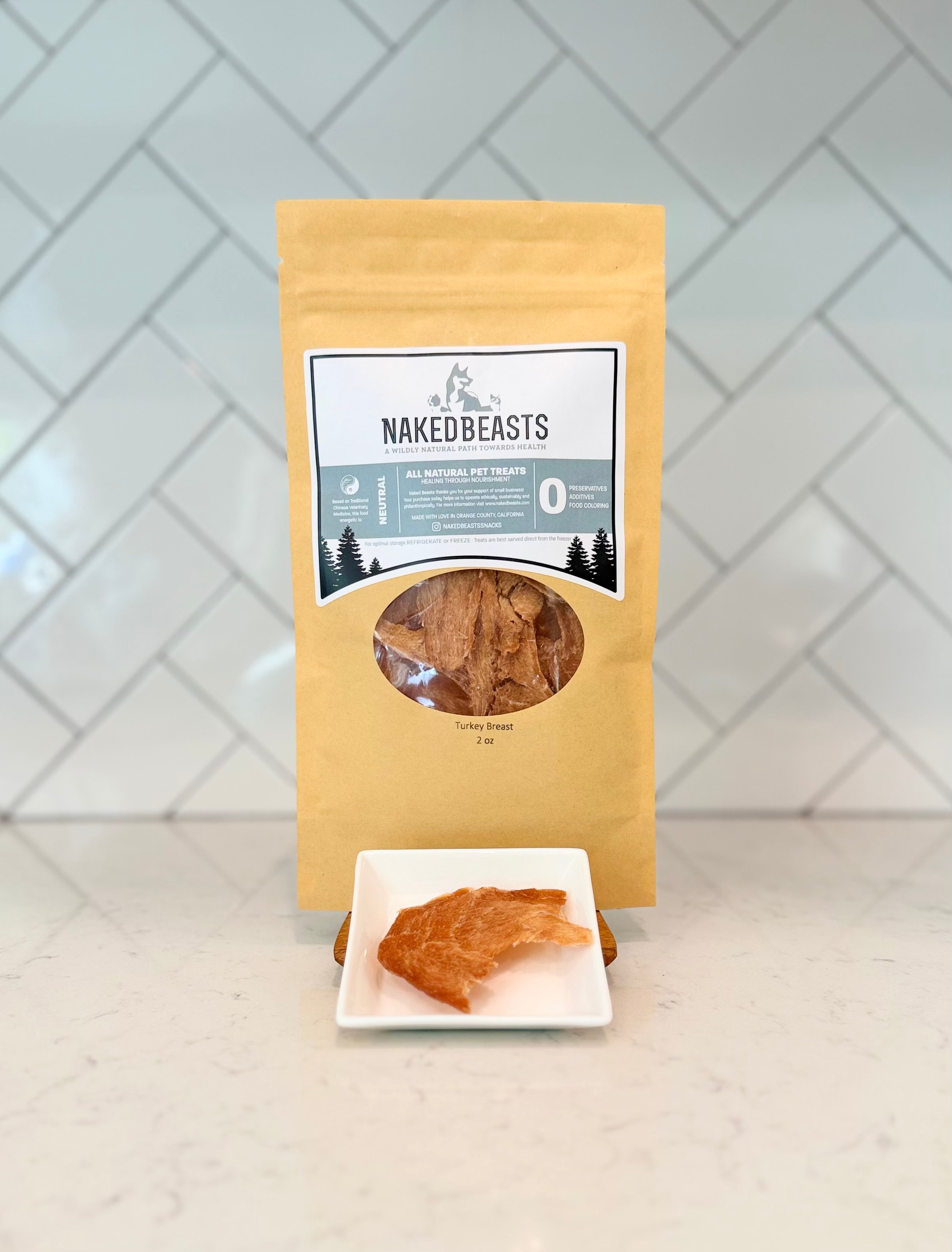 Naked Beasts packaging with a sample of Turkey Breast Snack on a white surface and tiled wall background
